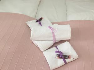 two towels with purple bows sitting on a bed at Lugarnica in Zagreb +126 photos