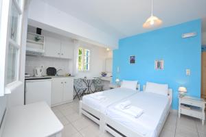 ein Schlafzimmer mit einem weißen Bett und einer blauen Wand in der Unterkunft Pension Sofia Amorgos in Katápola