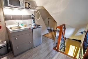 a small kitchen with a sink and a microwave at Le Compostelle de Conques in Conques-en-Rouergue