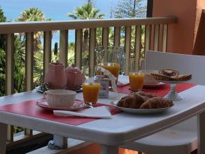 a table with breakfast food and orange juice on a balcony at Residence Imperiale in Sanremo