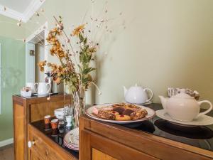 - une table avec une assiette de nourriture et une théière dans l'établissement Charming Rooms Opuntia, à Carloforte