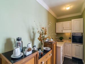 Charming Rooms Opuntia في كارلوفورتي: مطبخ مع طاولة عليها إناء من الزهور