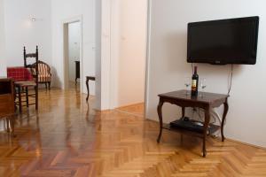 una sala de estar con TV y una mesa con una botella de vino en Apartment Ina en Split