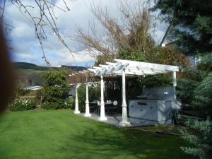 a pergola with a grill in a yard at Country Lane Homestay B&b in Palmerston North