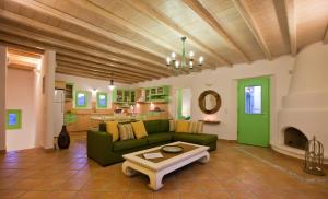 Una sala de estar con un sofá verde y una mesa. en Naoussa Bay Villas, en Naousa