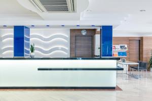 un hall de bureau avec un comptoir de réception blanc et bleu dans l'établissement Hotel Vista Park, à Can Picafort