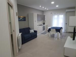 ein Wohnzimmer mit einem blauen Sofa und einem Tisch in der Unterkunft The Sweet Home of Milazzo in Milazzo