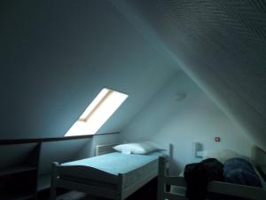 a attic room with a bed and a window at Les grands pins in Fiquefleur-Équainville