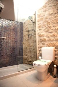 a bathroom with a toilet and a glass shower at Hotel del Sitjar in Calaceite
