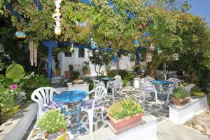 a group of tables and chairs in a garden at Pension Sofia Amorgos-Katapola in Katapola