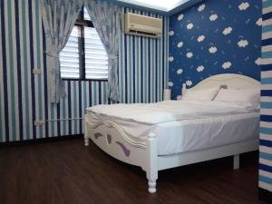 Un dormitorio con una cama con una pared azul y blanca en Tai Yu Ju Bao Fang B&B, en Yung-an-ts'un