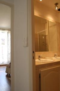 a bathroom with two sinks and a large mirror at Appart charme Arenes Nimes in Nîmes +36 photos