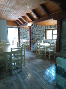 una sala da pranzo con tavoli e sedie in un edificio di Guest House Flodisa a Theth