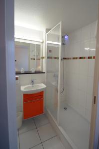 a white bathroom with a sink and a shower at The Originals City, Hôtel Alizéa, Le Mans Nord (Inter-Hotel) in Saint-Saturnin