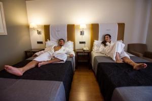 a hotel room with two beds and two couches at Hotel Spa Balfagon in Cantavieja