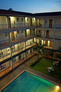 an apartment building with a swimming pool in front of it at Ivys Hotel in Kampala