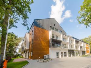 an apartment building with a wooden facade at Apartament 59 Dwie Sosny in Ustronie Morskie