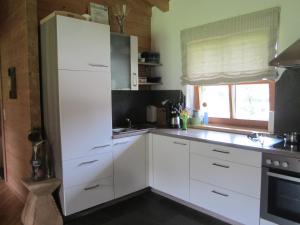 a kitchen with white cabinets and a sink and a window at Ferienhaus Mandlhof in Weer
