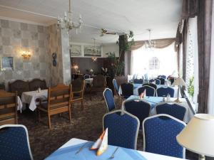 a dining room with blue tables and chairs at Hotel Cafe Bothe in Wolfshagen
