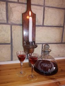 two glasses of wine and a candle on a table at DeKat Self Catering in Burgersdorp