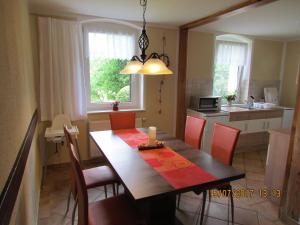 une cuisine et une salle à manger avec une table et des chaises dans l'établissement Ferienwohnung Apartement am Wolfsberg, à Reinhardtsdorf