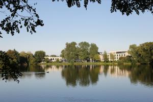 a view of a lake with a building in the background at See Park Janssen in Geldern