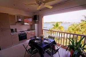 eine Küche und ein Esszimmer mit Meerblick in der Unterkunft flamboyant in Marigot