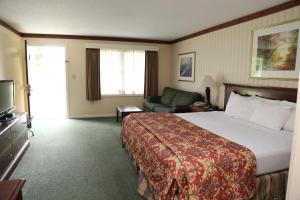 a hotel room with a large bed and a couch at Fairbanks Inn in St. Johnsbury