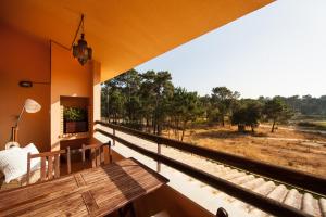 a balcony with a table and a view of a field at bwelcome aroeira beach & golf in Charneca