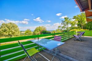 - une table et des chaises sur la terrasse d'une maison dans l'établissement Logis Hôtel Restaurant Le Chalet du Mont Roland, à Dole