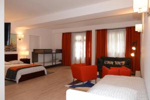サン・テニャンにあるLes Chambres Pandaのベッド2台、ソファ、椅子が備わるホテルルームです。