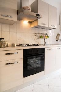 a kitchen with white cabinets and a black oven at Appartamento in centro in Genoa