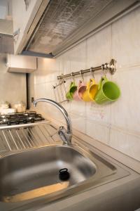 a kitchen sink with a faucet and cups on the wall at Appartamento in centro in Genoa