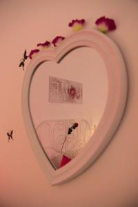 a heart shaped mirror on a wall with flowers at Appartamento in centro in Genoa