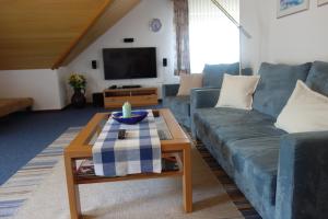 a living room with a blue couch and a coffee table at Haus Waldblick in Hagen