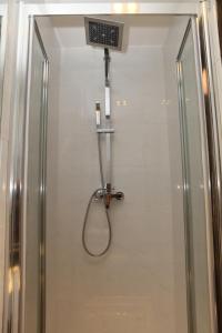 La salle de bains est pourvue d'une douche avec un pommeau de douche. dans l'établissement Exhibition Court Hotel 4, à Londres