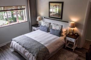 
a bedroom with a bed and a window at Wild Olive Guest House in Cape Town
