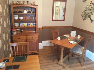 a dining room with a wooden table and chairs at The Ivy House Ferry Link in Stranraer