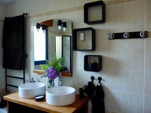 a bathroom with two white sinks and a mirror at Suite à 800m de la plage in Saint-Lunaire