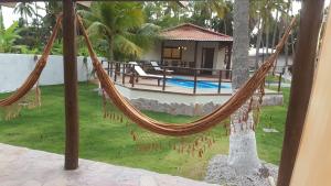 a hammock in front of a house at Country Club Pititinga in Pititinga