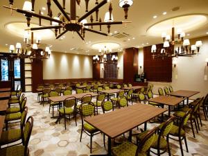 a dining room with tables and chairs and a chandelier at S.Training Center Hotel Osaka in Osaka