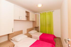 a bedroom with two beds and a green curtain at Apartments Villa-Ines Center in Vodice