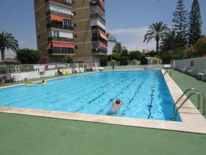 a person swimming in a large swimming pool at Cala Regina in San Juan de Alicante