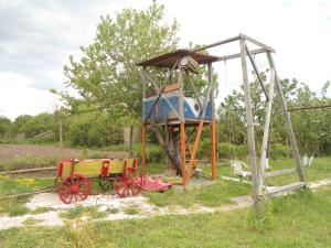 plac zabaw z drewnianym wózkiem na polu w obiekcie Granichar 1 Caravan w mieście Granichar