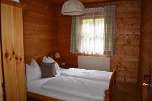 ein Schlafzimmer mit einem Bett in einer Holzhütte in der Unterkunft Apartment Lehengut in Eben im Pongau