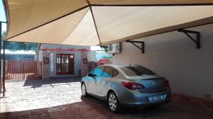 a car parked in front of a building with a large tent at Dreams in Beaufort West