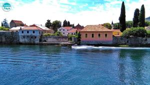a boat in a river with houses and buildings at Apartman Park in Trebinje