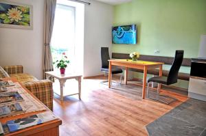 ein Wohnzimmer mit einem Tisch und einem Sofa in der Unterkunft Lindenhof Residence Meran in Meran
