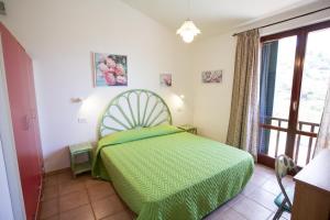 a bedroom with a green bed and a window at Appartamenti Morcone - Goelba in Capoliveri