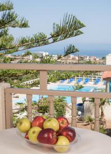 een fruitschaal op een tafel met uitzicht op een resort bij Panorama-Seaview Studios & Apartments in Chersonissos